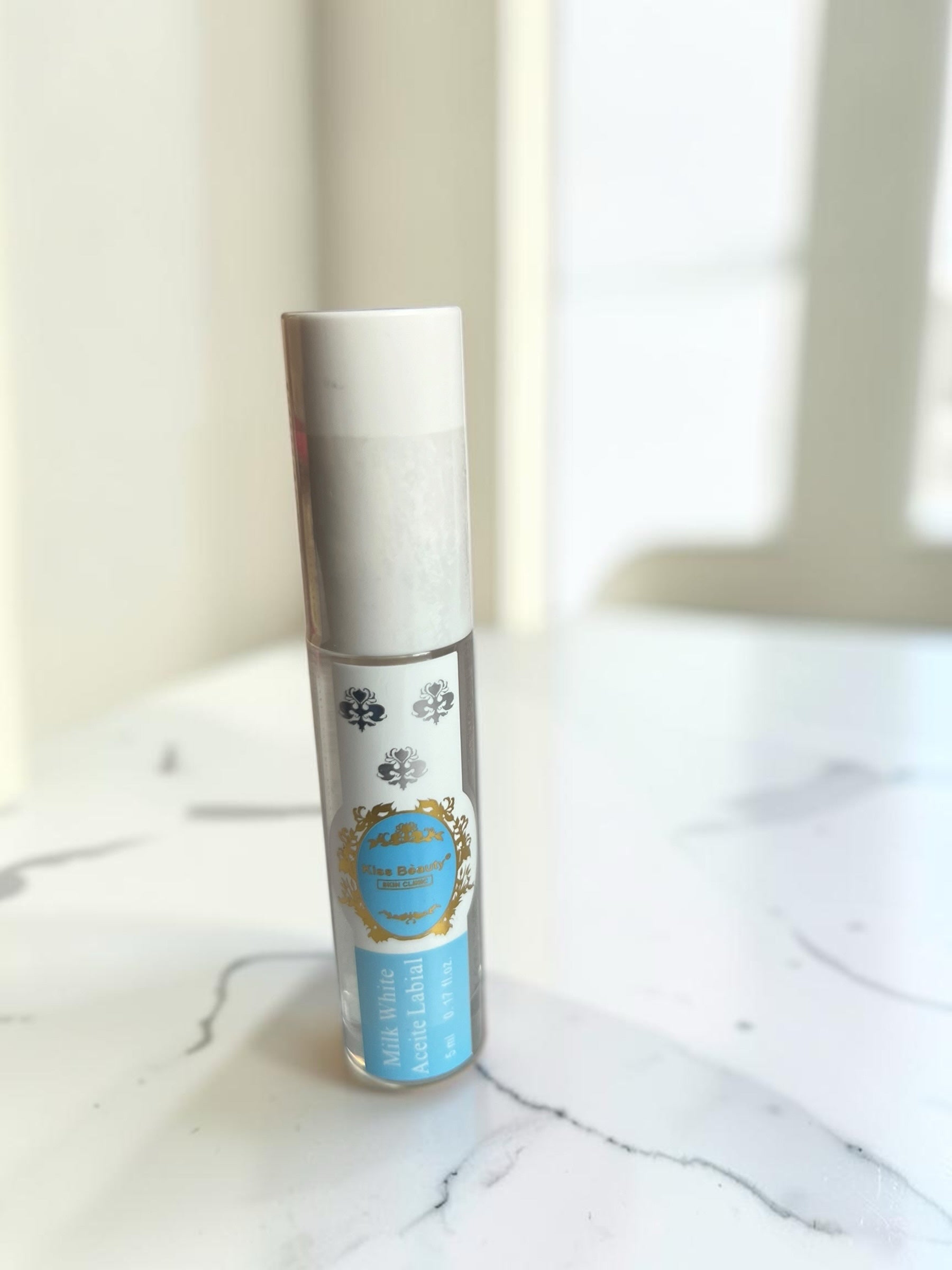 Aceite labial hidratante Milk White de Selsebil en envase transparente con etiqueta azul y detalles dorados